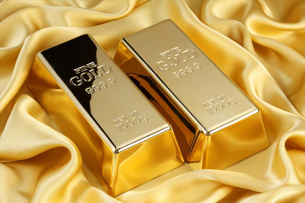 two 24 karat pure gold bars on yellow satin background