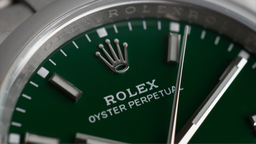 silver Rolex watch with green face